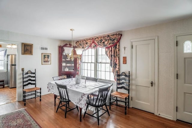 dining area featuring a notable chandelier and hardwood / wood-style flooring