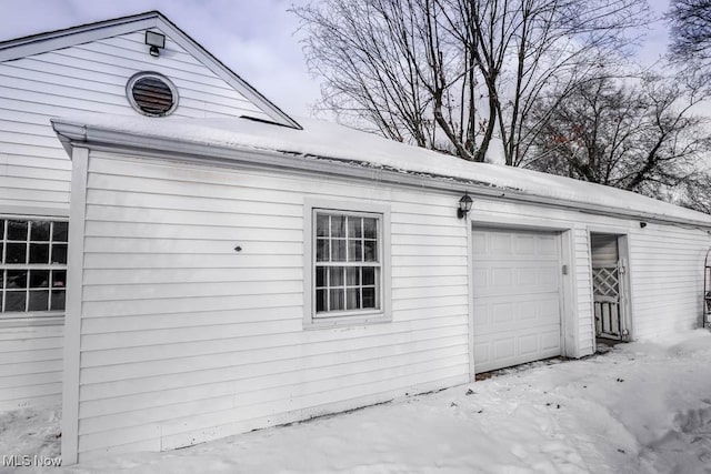 view of snow covered exterior with a garage and an outdoor structure