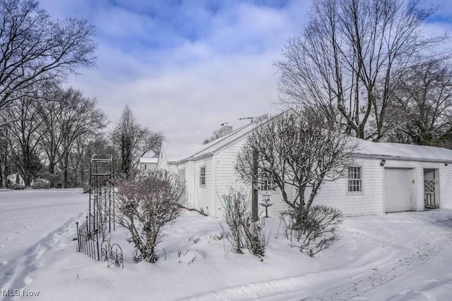 view of snow covered exterior with a garage