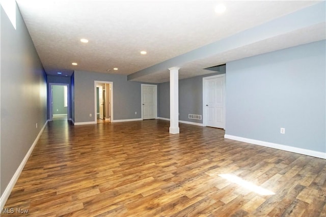 spare room with ornate columns and wood-type flooring