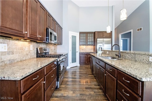 kitchen featuring pendant lighting, stainless steel appliances, sink, and decorative backsplash