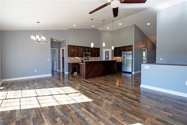 kitchen with appliances with stainless steel finishes, hanging light fixtures, high vaulted ceiling, a center island, and dark brown cabinetry