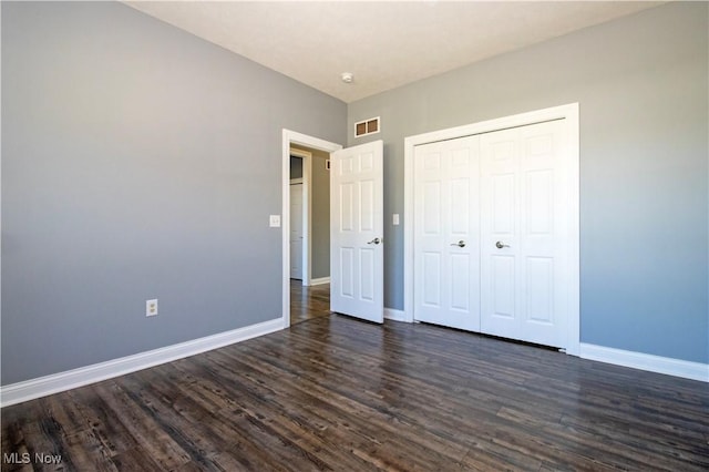 unfurnished bedroom featuring dark hardwood / wood-style floors and a closet