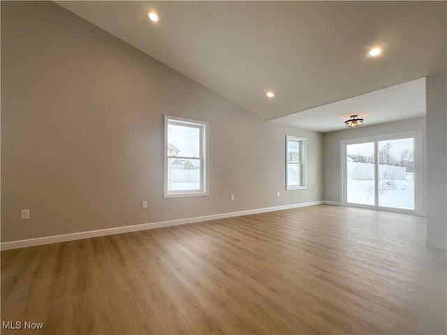 spare room featuring high vaulted ceiling, light wood-style flooring, baseboards, and recessed lighting