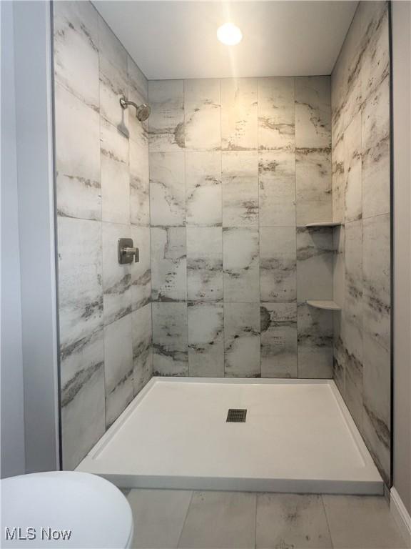 bathroom with walk in shower and toilet