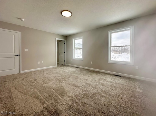 unfurnished room featuring carpet floors, baseboards, and visible vents