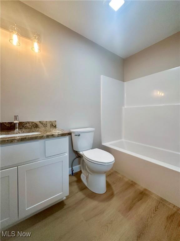 full bathroom featuring shower / tub combination, vanity, and toilet