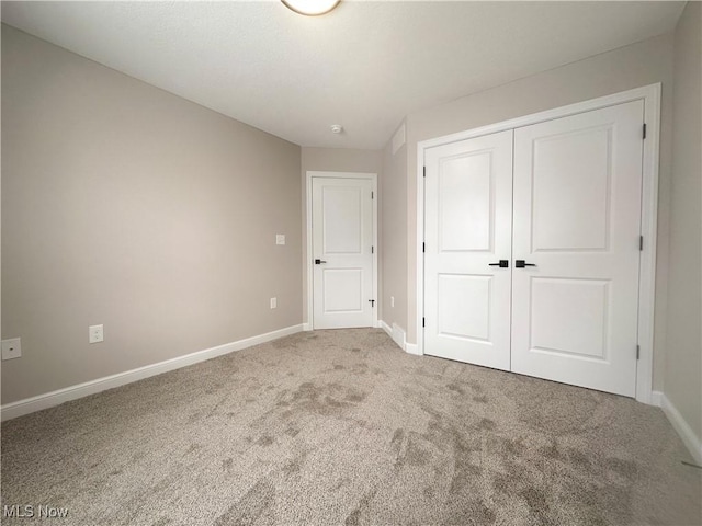 unfurnished bedroom featuring carpet floors and a closet