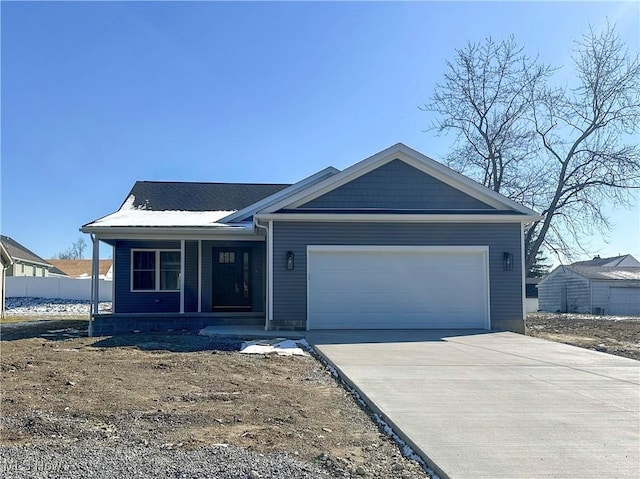 view of front of house with a garage, covered porch, and driveway