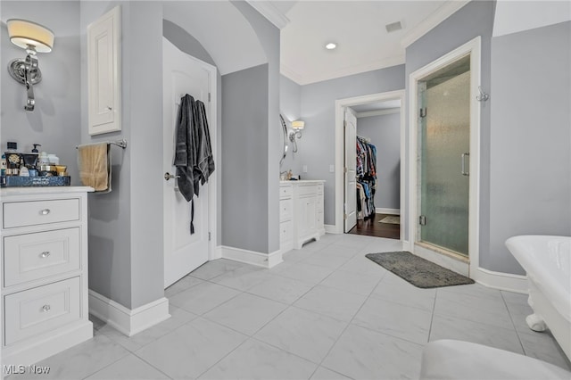 bathroom with vanity, crown molding, and a shower with door