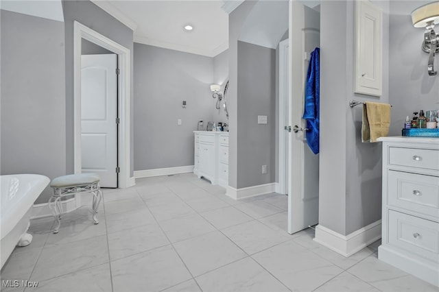 bathroom featuring ornamental molding, a bathing tub, and vanity