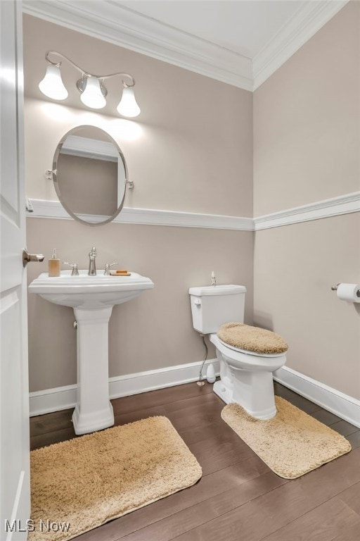 bathroom featuring hardwood / wood-style flooring, ornamental molding, and toilet