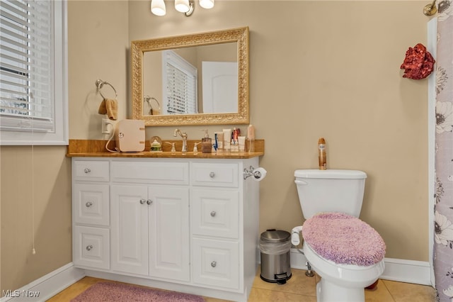 bathroom with a healthy amount of sunlight, vanity, toilet, and tile patterned floors