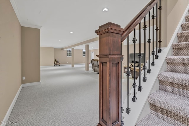 stairway with crown molding and carpet