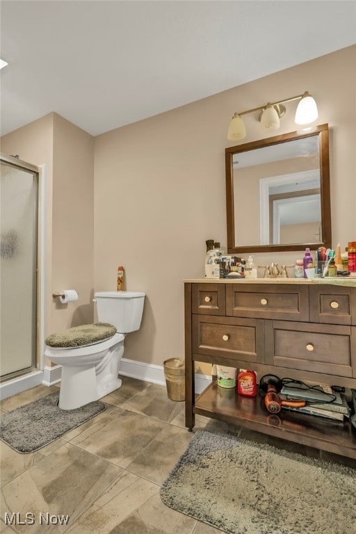 bathroom with an enclosed shower, vanity, and toilet