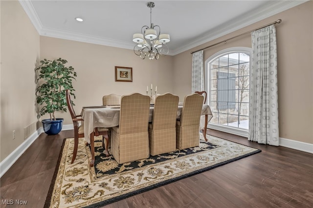 dining room with dark hardwood / wood-style flooring, crown molding, and an inviting chandelier