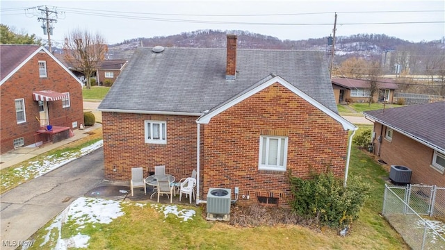 rear view of property featuring a patio, a yard, and central AC unit