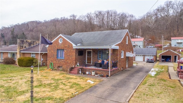 view of front facade with a porch, a garage, an outdoor structure, and a front lawn