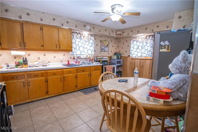 kitchen with stainless steel appliances, light tile patterned flooring, and ceiling fan