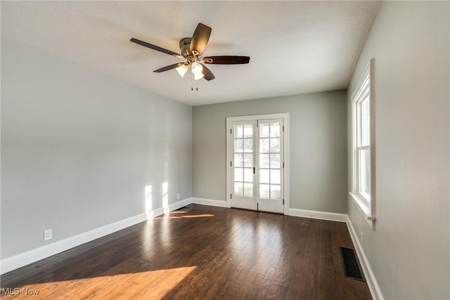 empty room featuring dark wood-type flooring, ceiling fan, and french doors