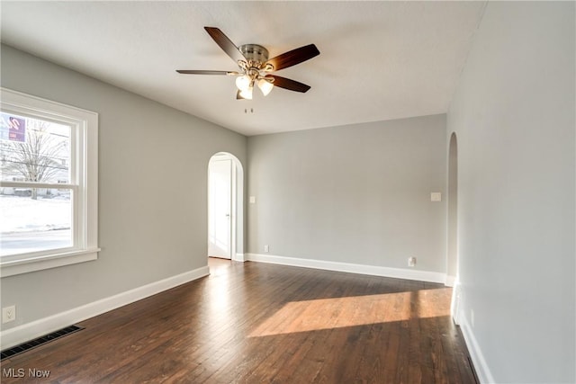 empty room featuring dark wood-type flooring and ceiling fan