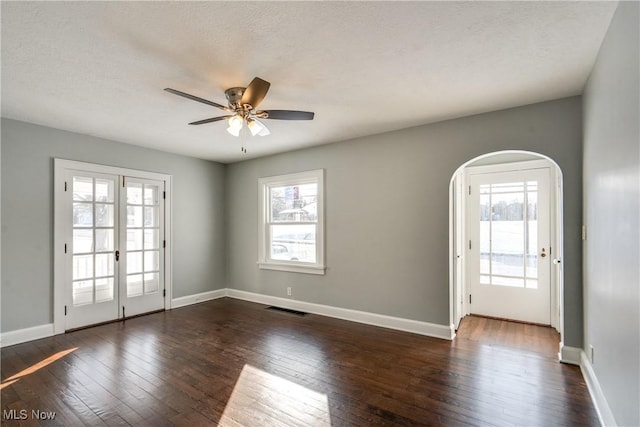 spare room featuring dark hardwood / wood-style floors, a textured ceiling, ceiling fan, and french doors