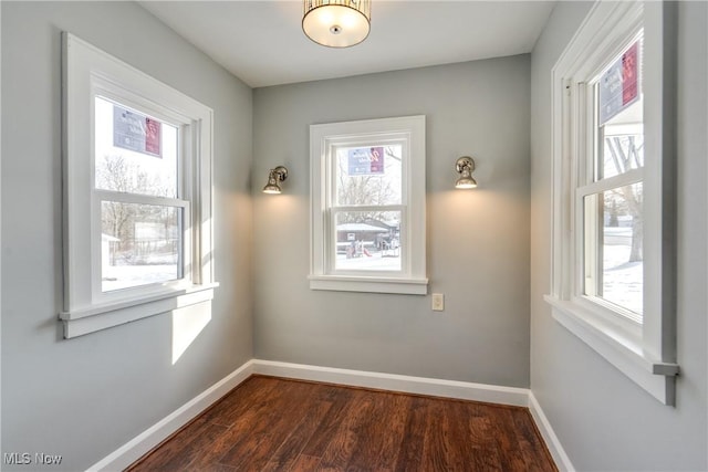 unfurnished room with dark wood-type flooring