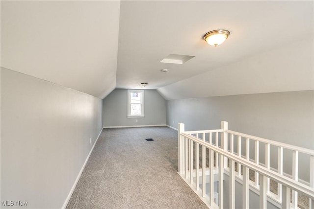 additional living space with vaulted ceiling and carpet