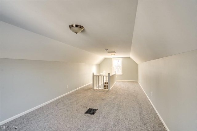 bonus room with lofted ceiling and carpet floors