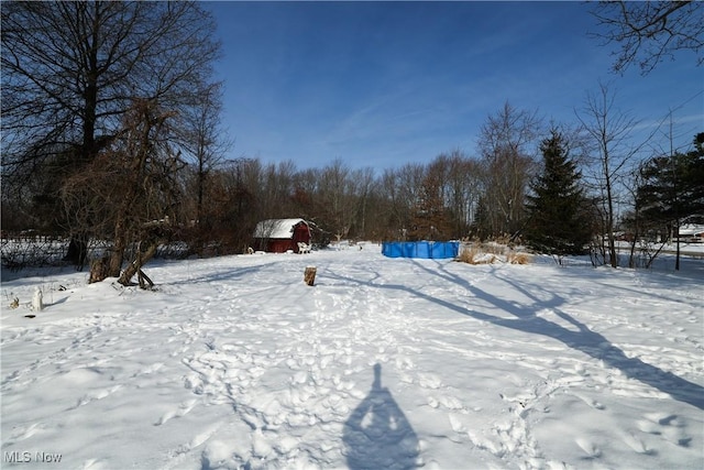 yard layered in snow featuring an outdoor structure