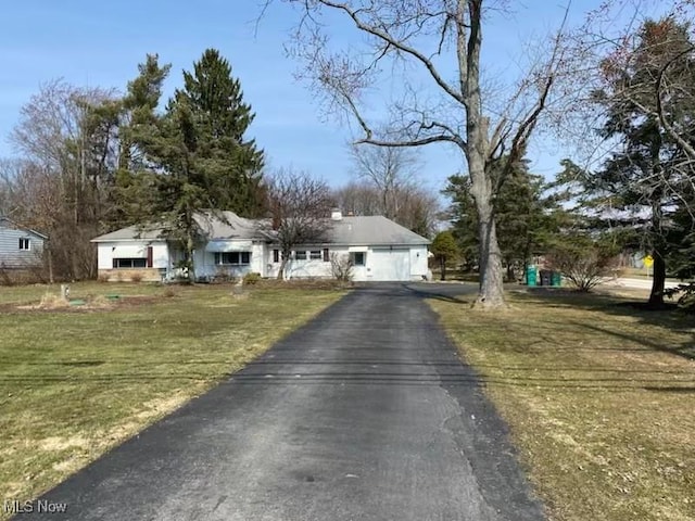 view of front of house featuring driveway, a front lawn, and a garage