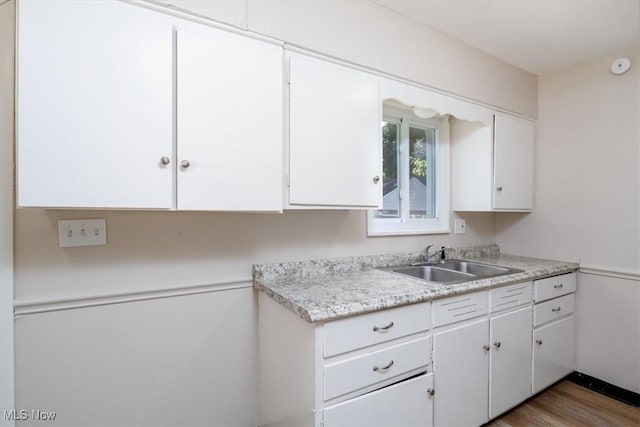 kitchen featuring white cabinetry, sink, and hardwood / wood-style floors