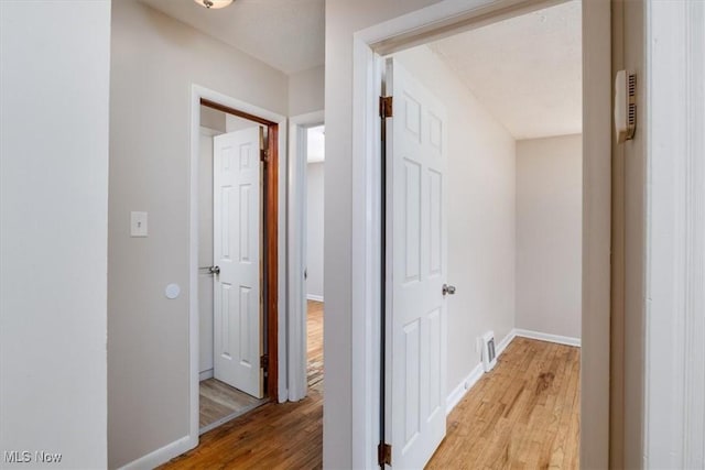 hallway with light hardwood / wood-style floors