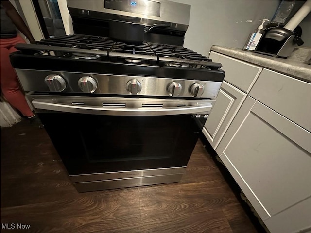 interior details featuring white cabinetry and gas range