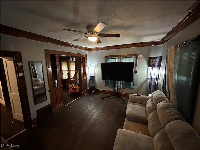 living room with ornamental molding, dark hardwood / wood-style floors, ceiling fan, and a textured ceiling