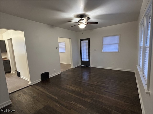 empty room with dark wood-type flooring and ceiling fan