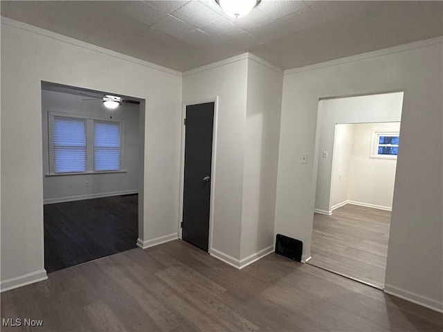 unfurnished room featuring wood-type flooring and crown molding