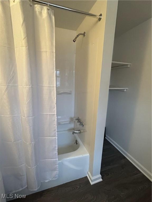 bathroom featuring hardwood / wood-style flooring and shower / bathtub combination with curtain