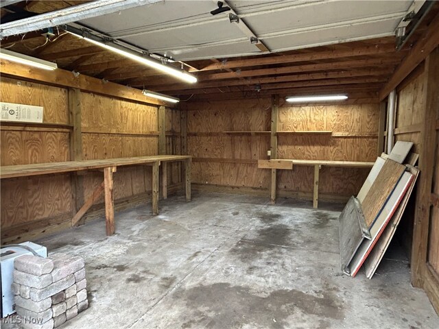 garage with a workshop area and wood walls