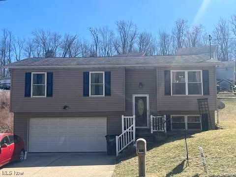 split foyer home with a front lawn, a garage, and driveway