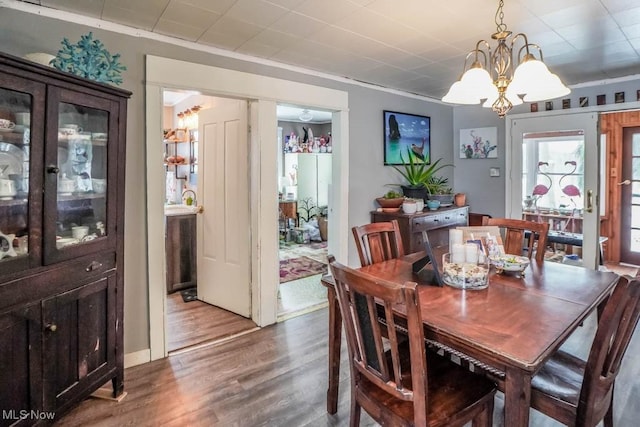 dining space featuring ornamental molding, hardwood / wood-style floors, and a notable chandelier