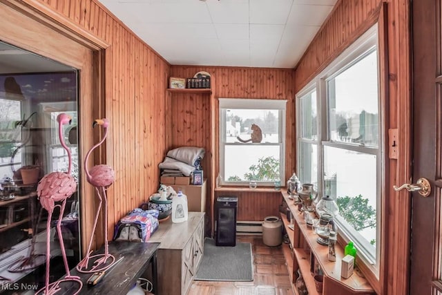 misc room with parquet floors, a baseboard radiator, and wooden walls