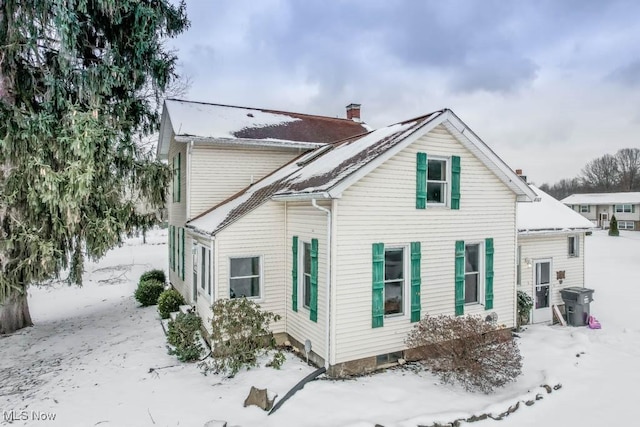 view of snow covered back of property