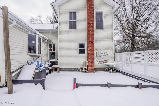 view of snow covered back of property