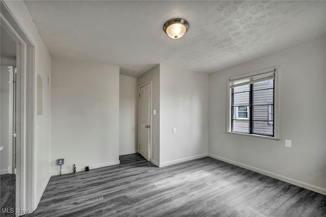 empty room featuring hardwood / wood-style flooring and a textured ceiling