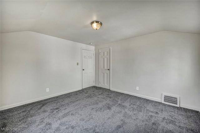 carpeted spare room with lofted ceiling