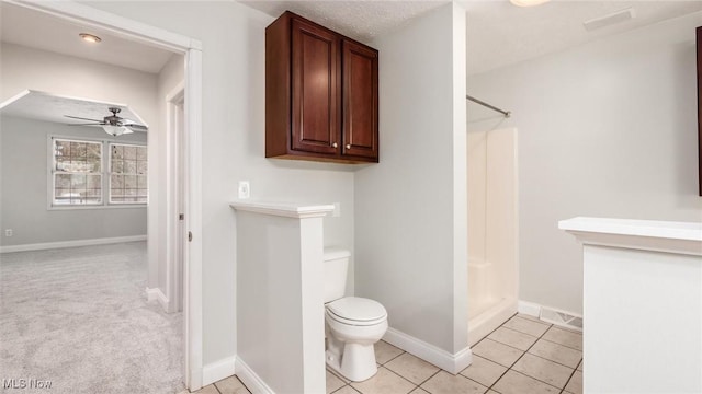 bathroom with tile patterned flooring, a shower, ceiling fan, and toilet