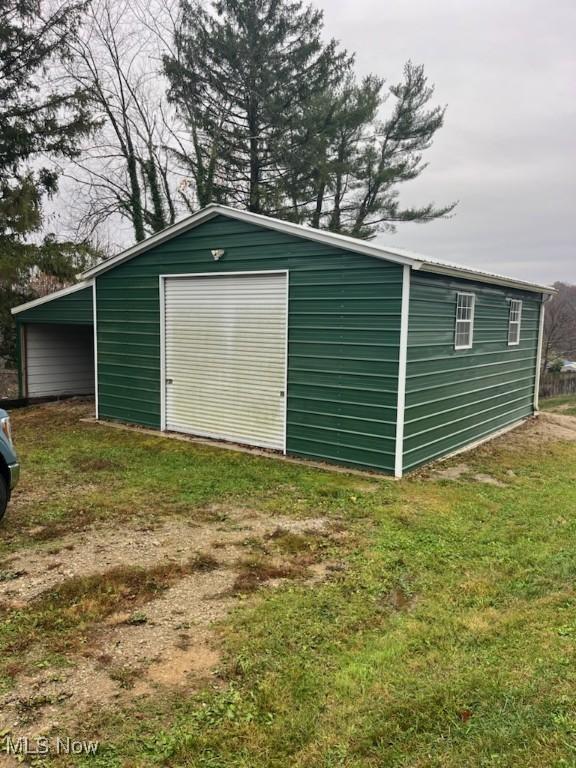 view of outdoor structure featuring a garage and a lawn