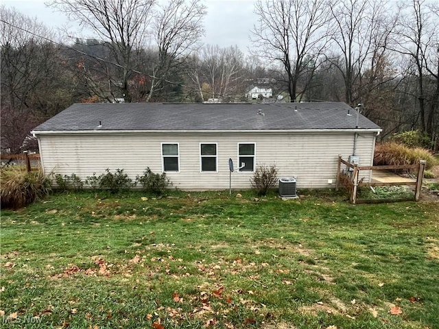 rear view of house with a yard and central AC unit