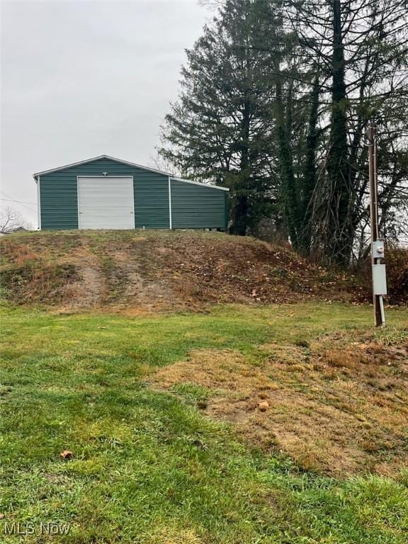 view of yard featuring a garage and an outdoor structure